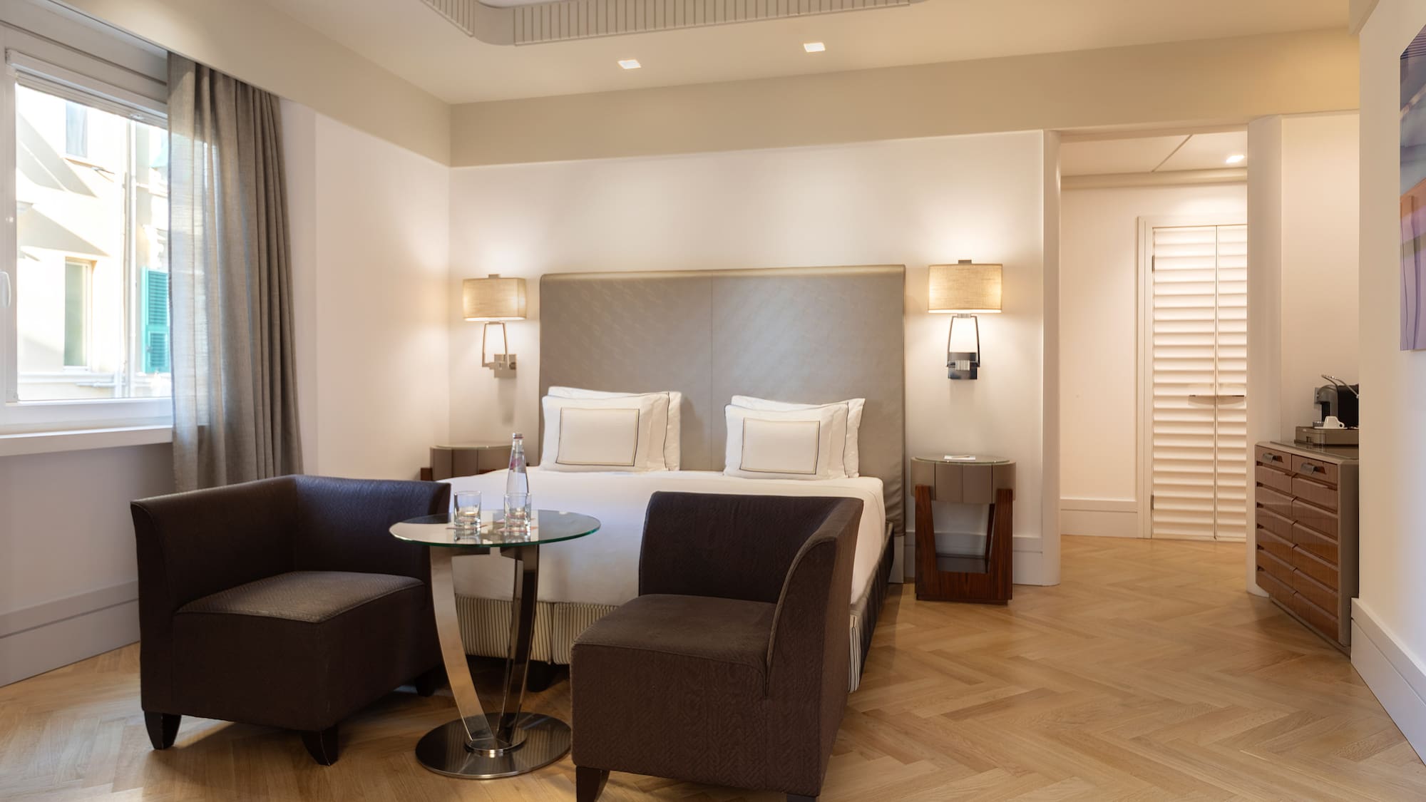 a room with a bed and chairs