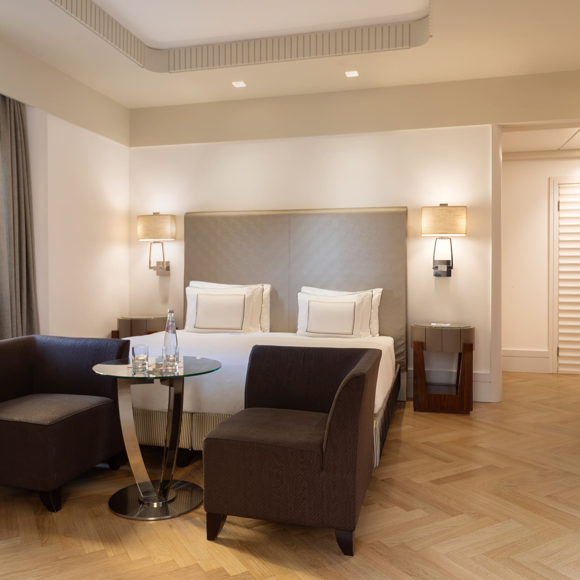 a room with a bed and chairs