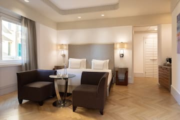 a room with a bed and chairs