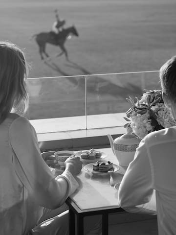 a couple sitting at a table with a horse in the background