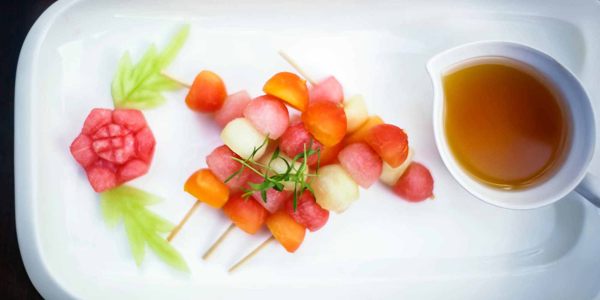 a plate of fruit and a cup of tea