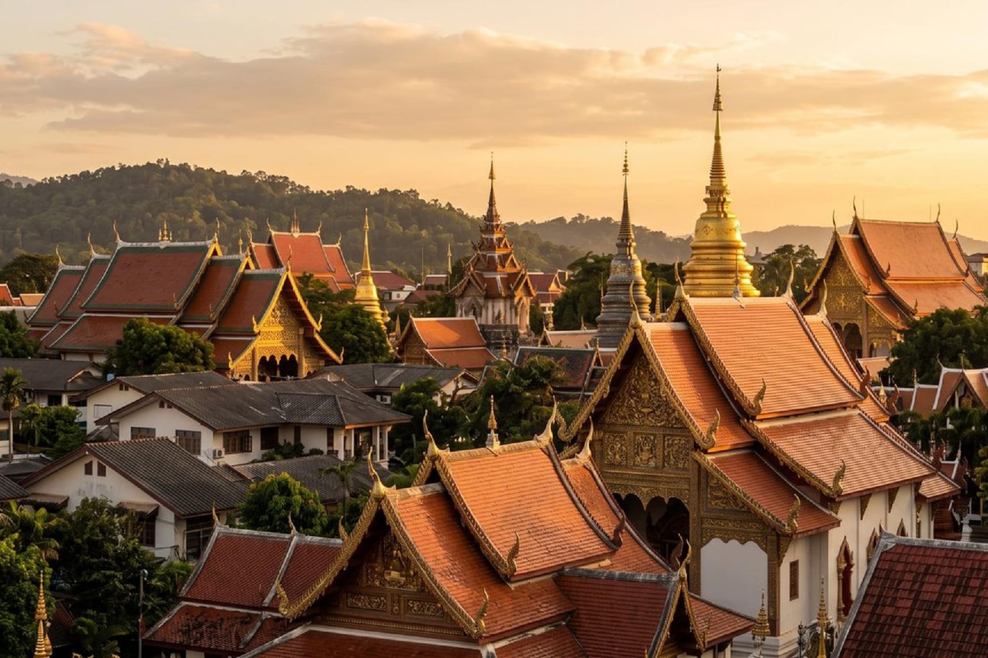 Golden spires and red-tiled roofs of Thai temples at sunset.