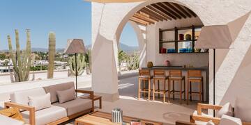 a patio with a bar and chairs