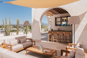 a patio with a bar and chairs