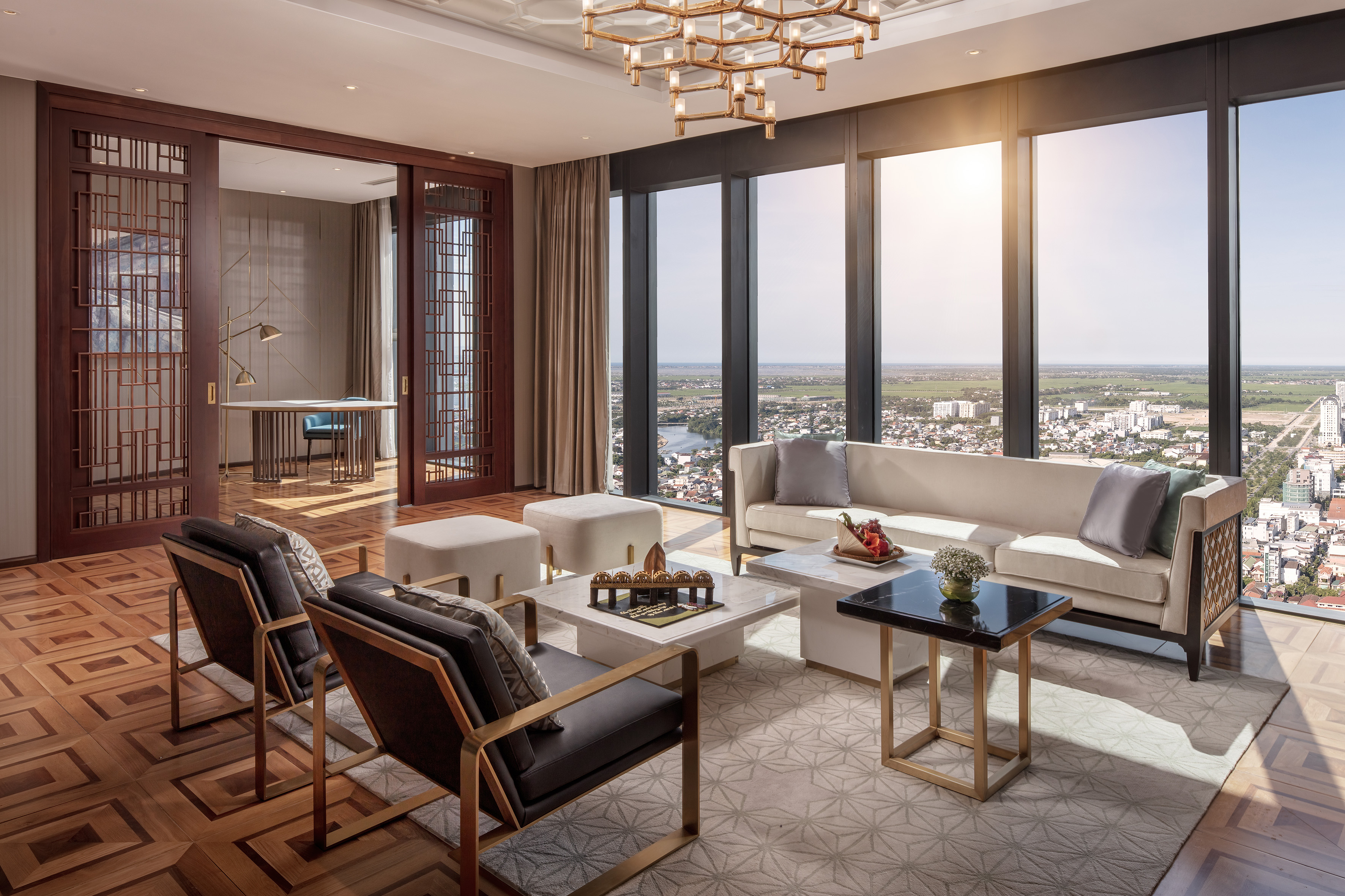 Luxury hotel living room with panoramic city view and modern decor.