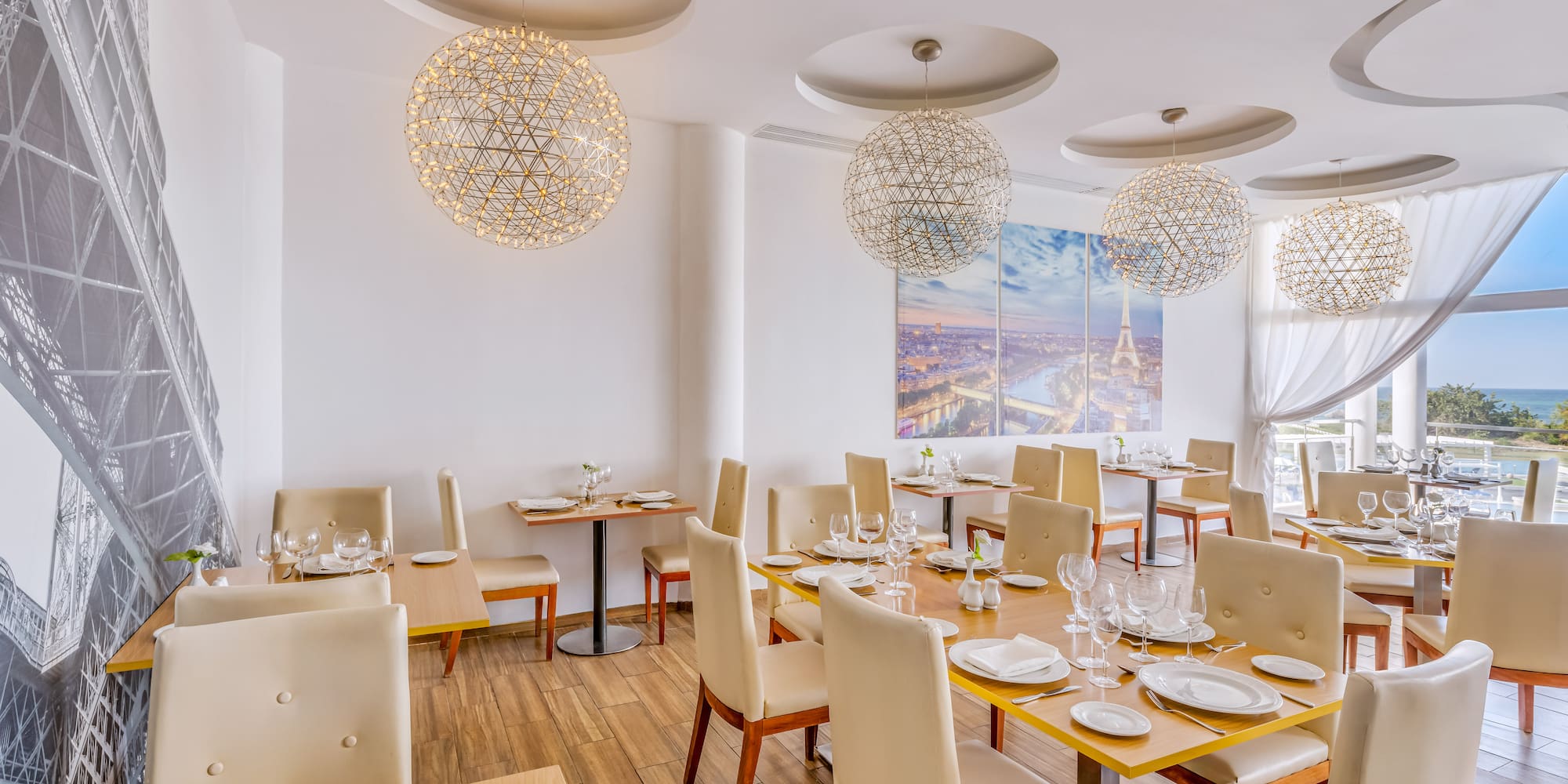 a room with tables and chairs and a painting on the wall