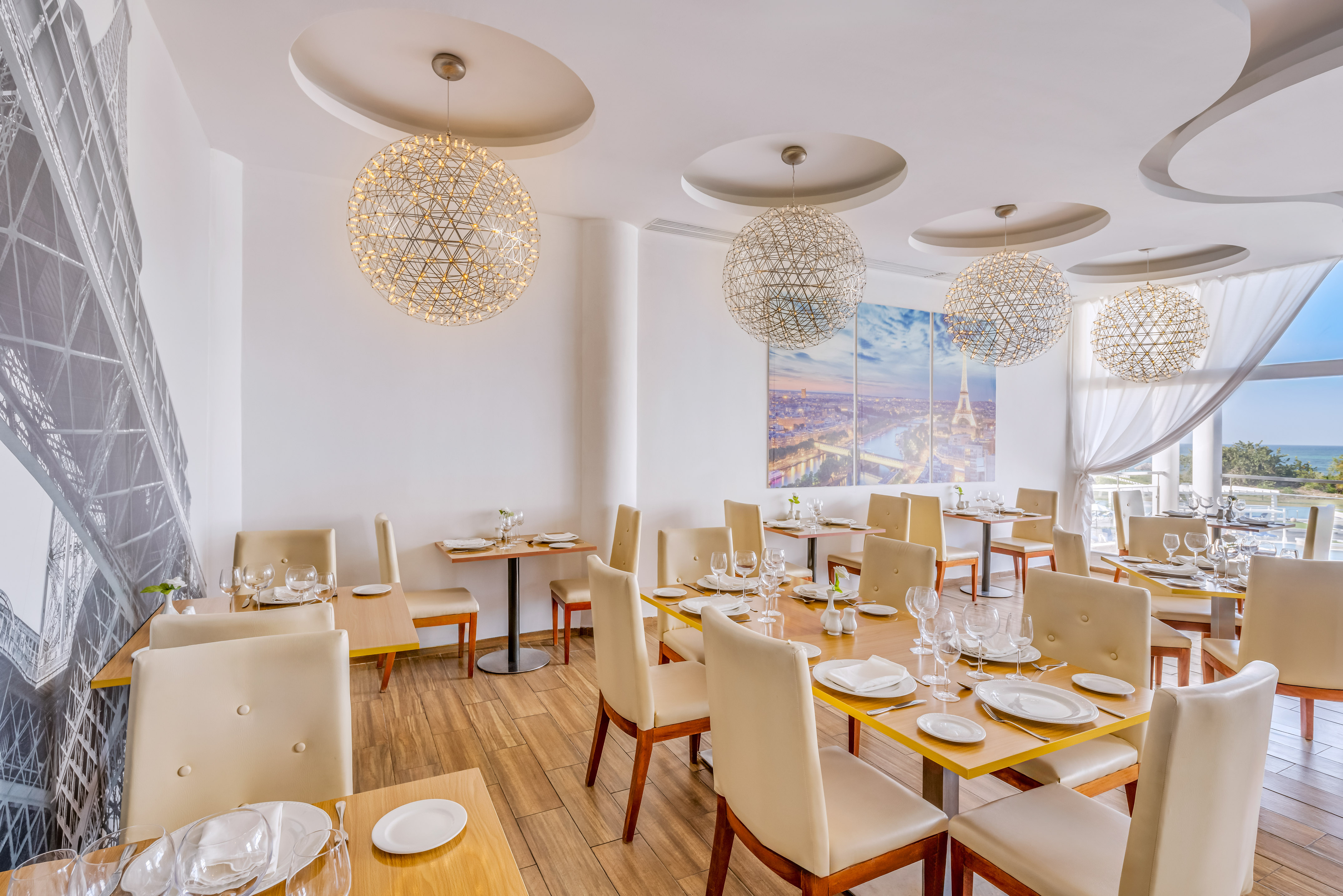 a room with tables and chairs and a painting on the wall