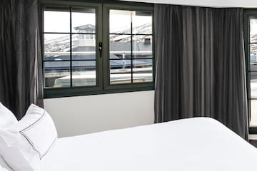 a bed with white sheets and black curtains