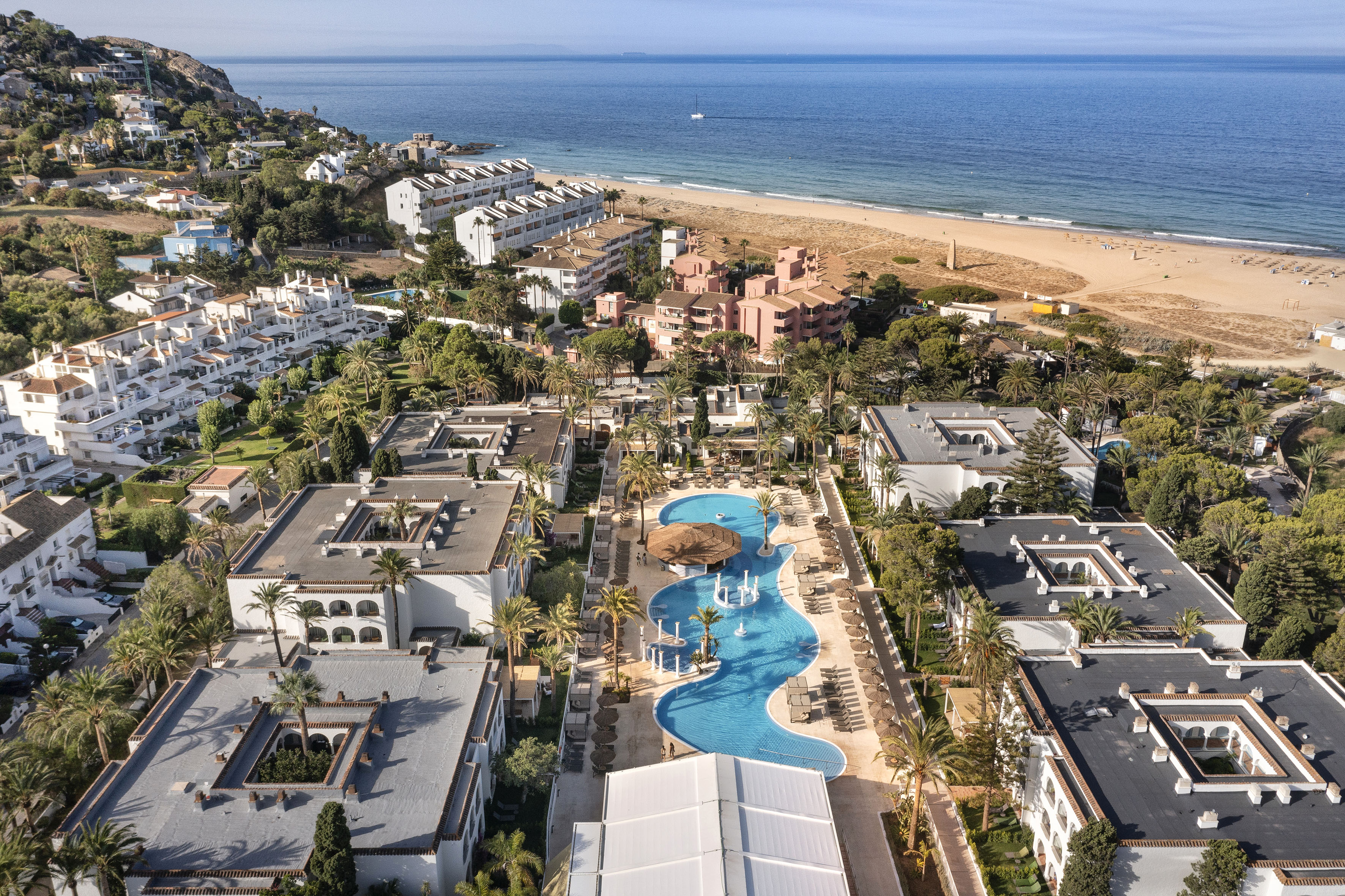 a swimming pool and buildings next to a beach