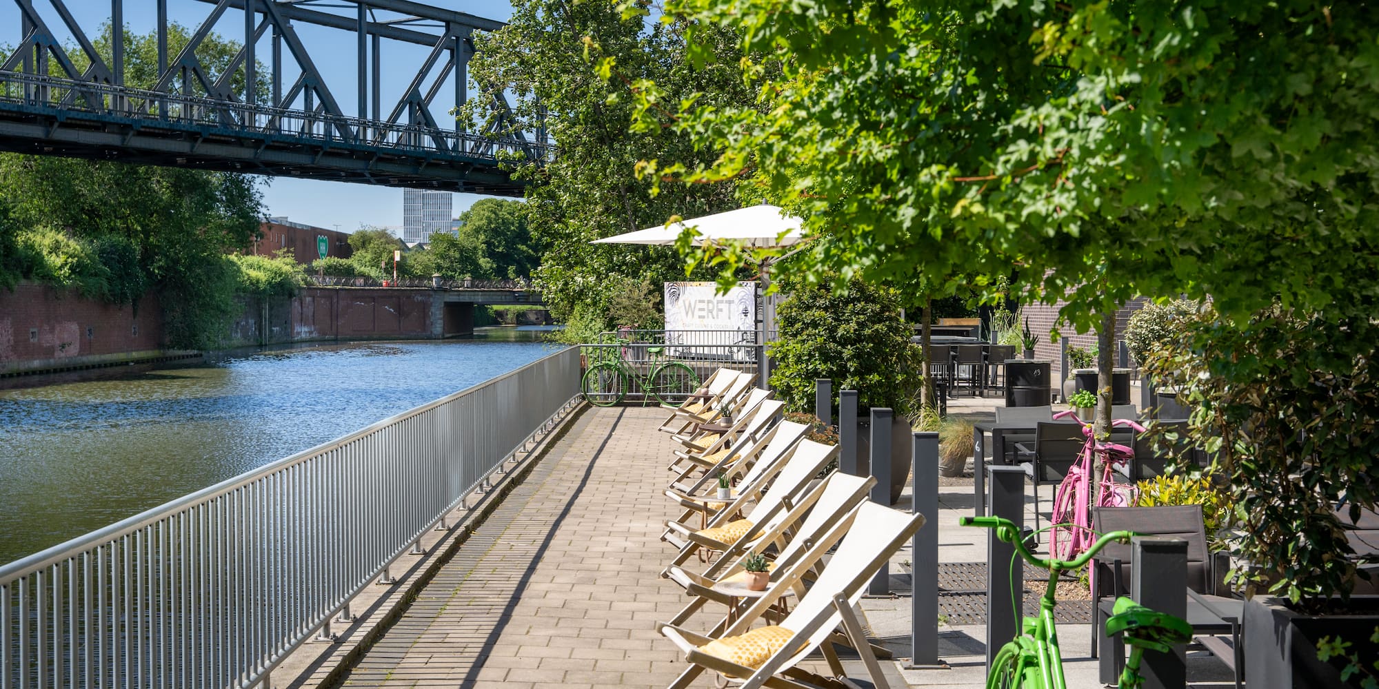 a row of chairs on a sidewalk next to a river