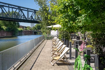 a row of chairs on a sidewalk next to a river