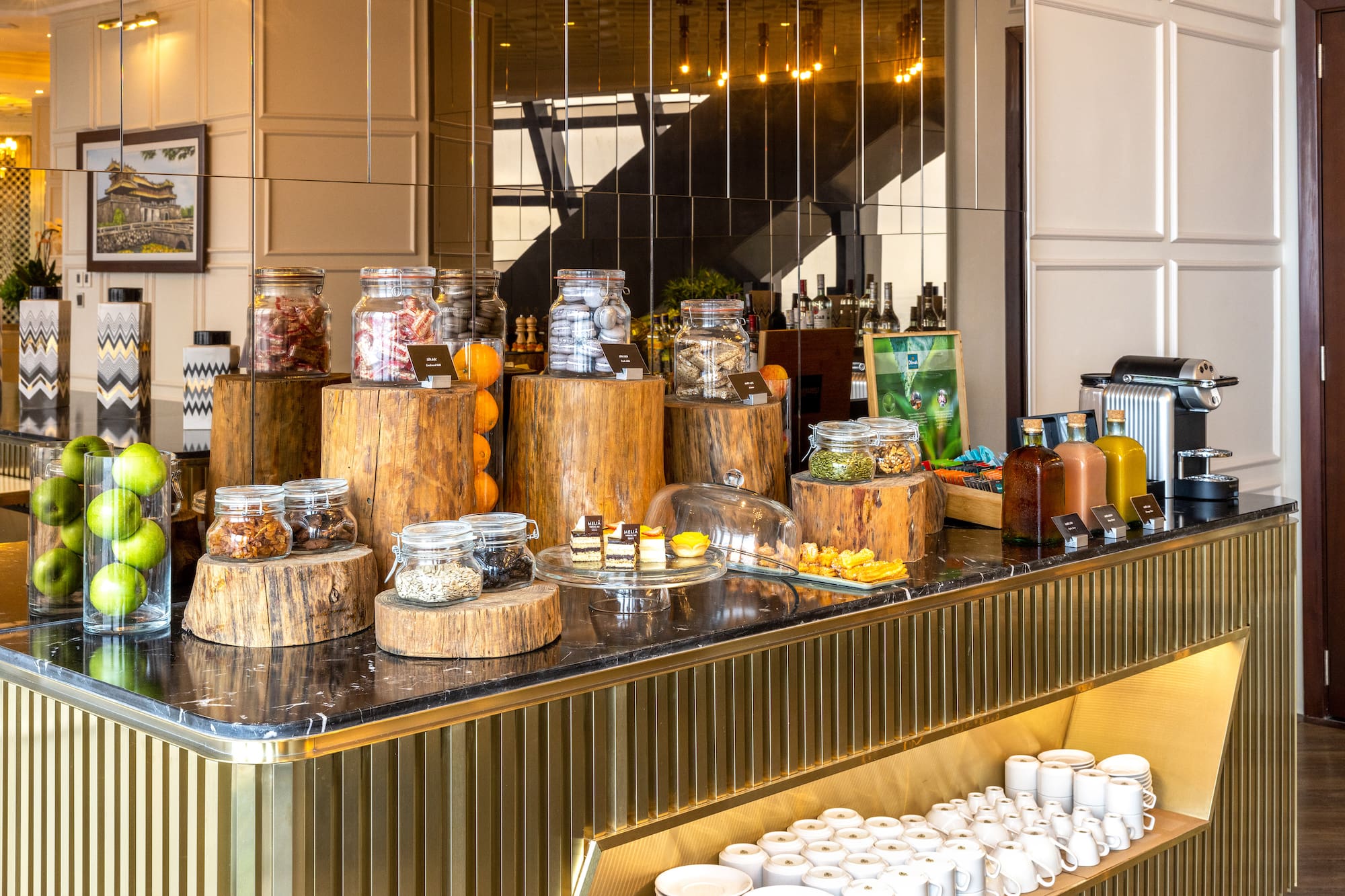 Hotel breakfast buffet: jars of nuts, seeds, granola, fruit, pastries, coffee.