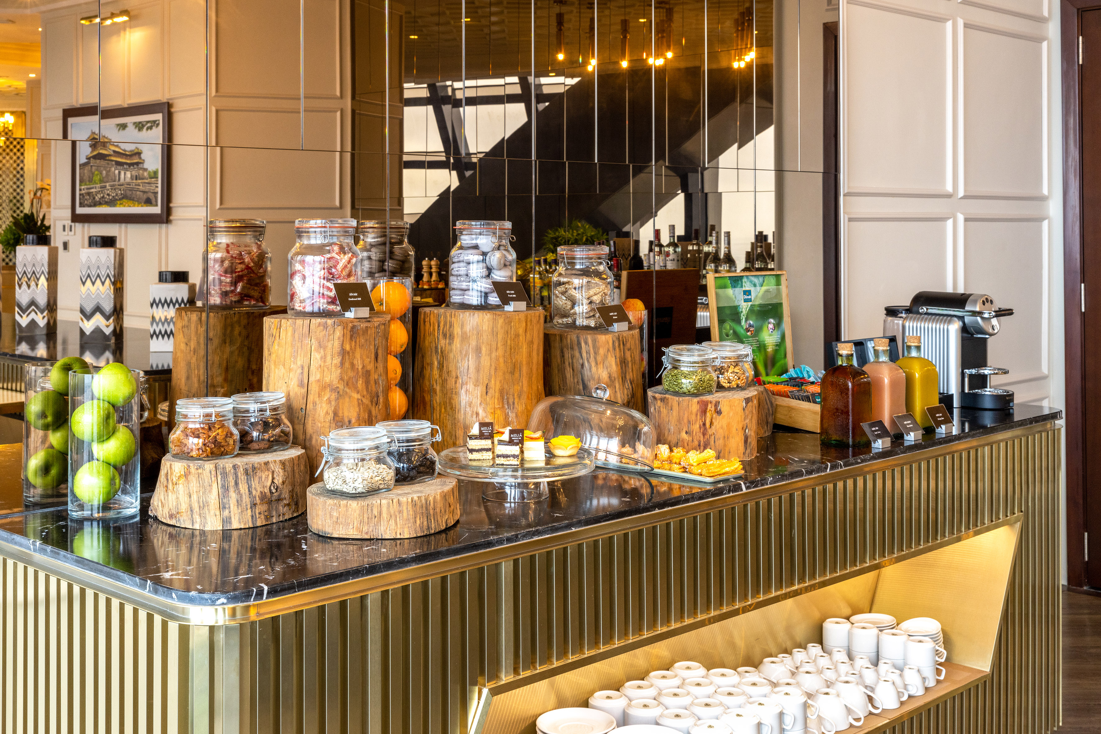 Hotel breakfast buffet: jars of nuts, seeds, granola, fruit, pastries, coffee.