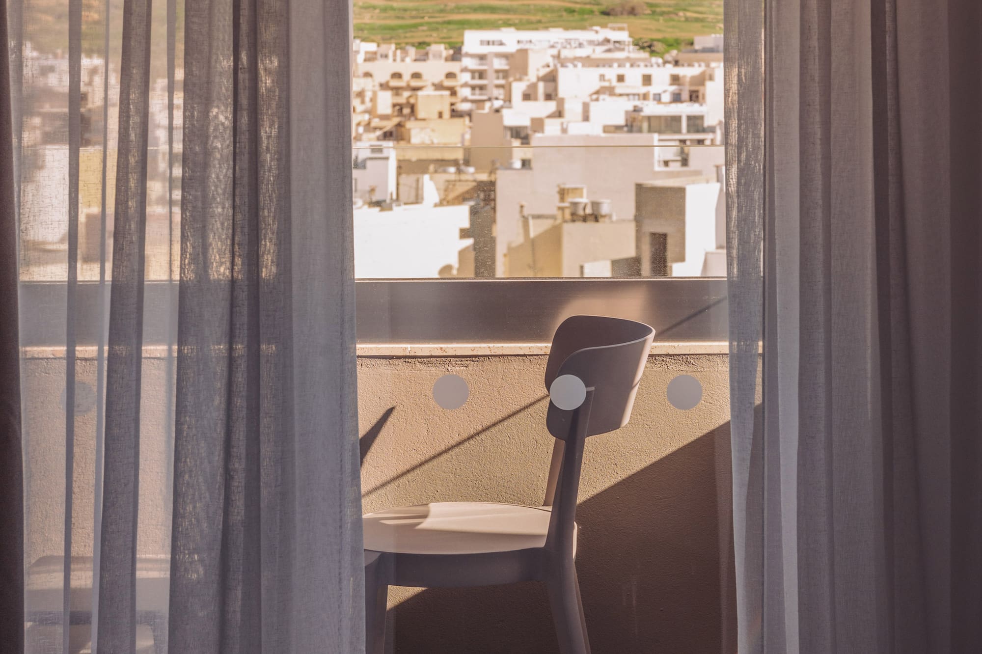 a chair and a window with curtains