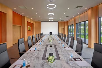 a conference room with a large table with chairs and a projector screen