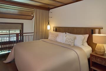 a bed with a wooden headboard and a lamp