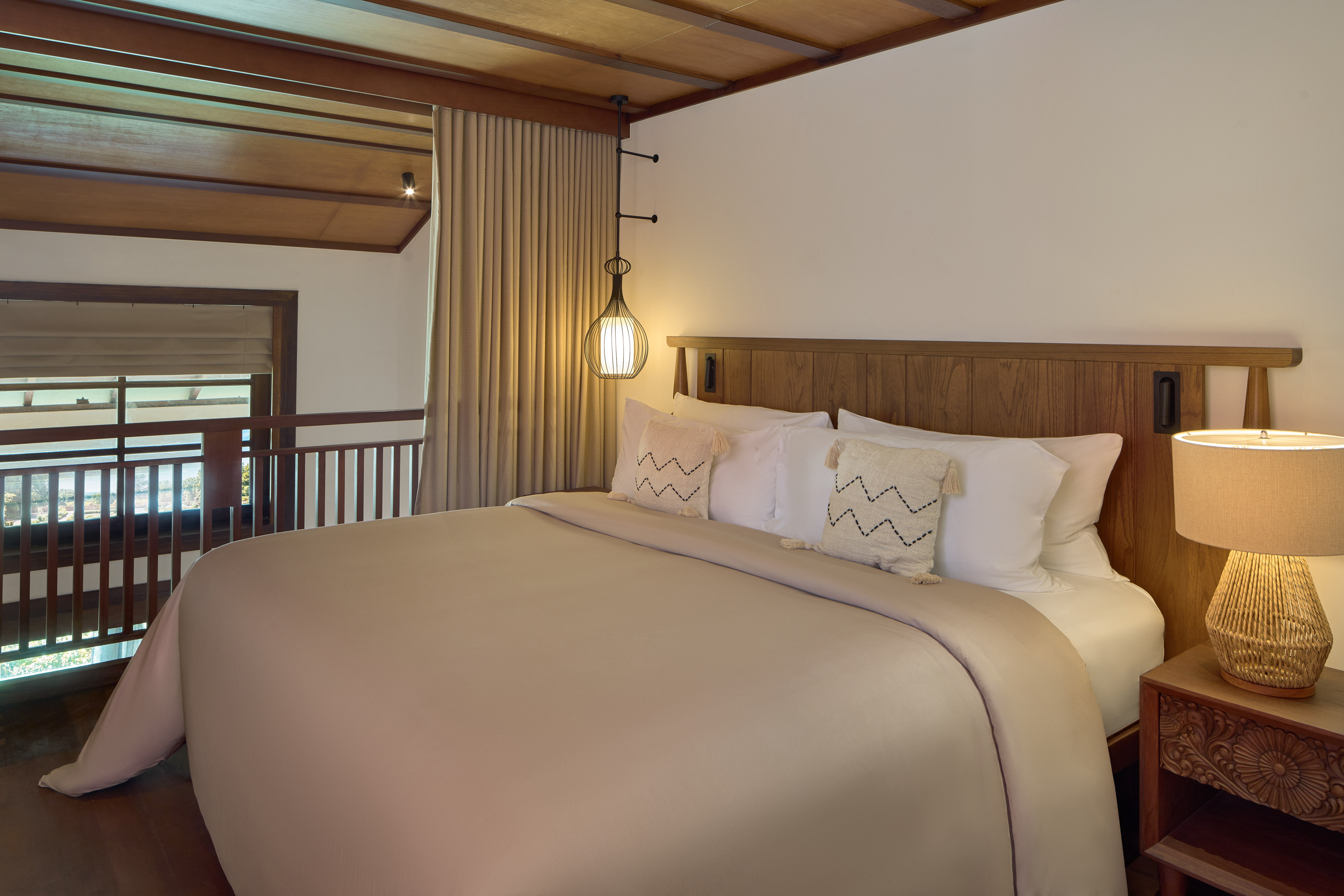 a bed with a wooden headboard and a lamp