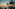 Tropical sunset over ocean with silhouetted palm trees.