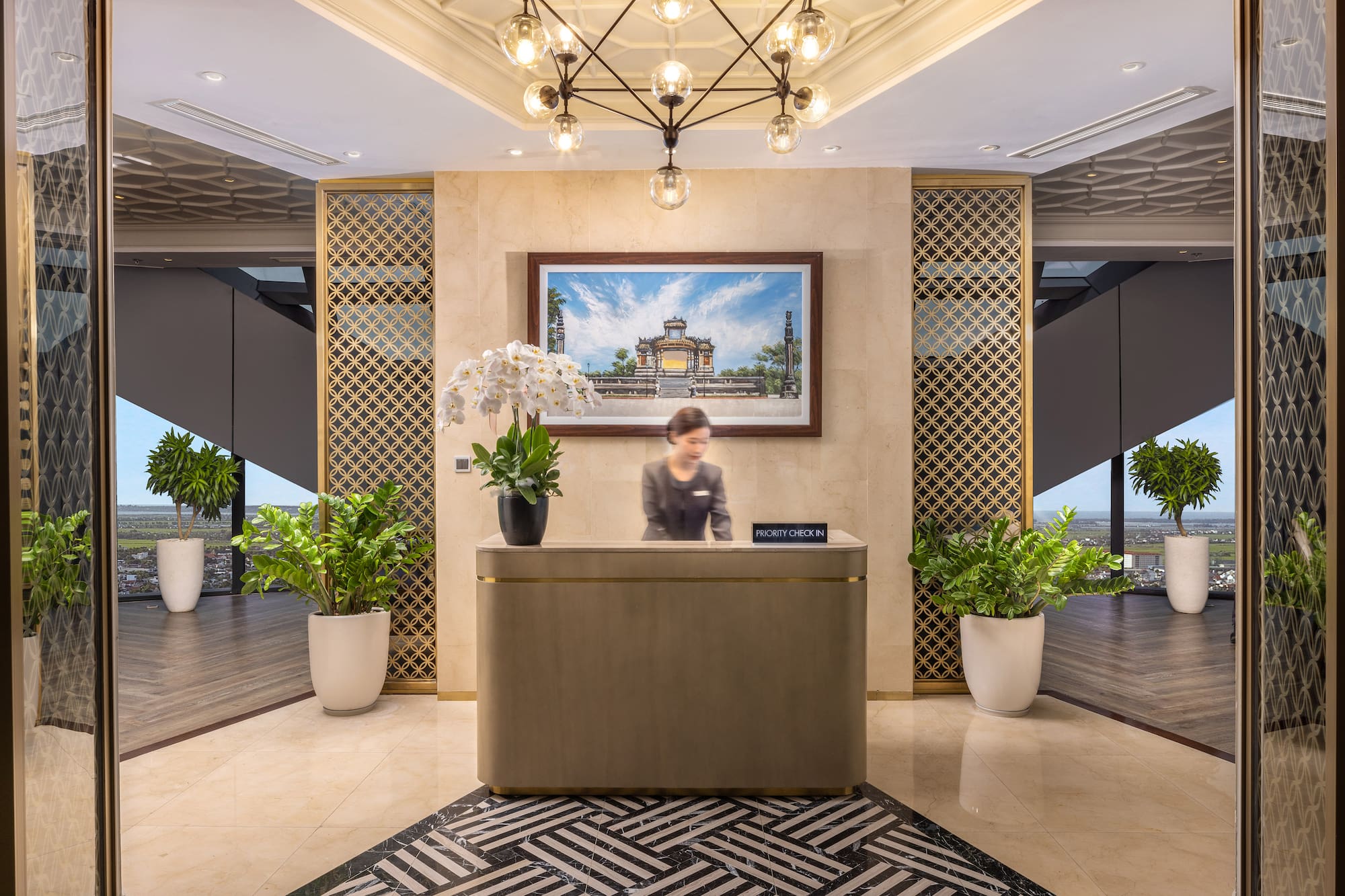 Luxury hotel reception with receptionist at modern desk, elegant lobby decor.