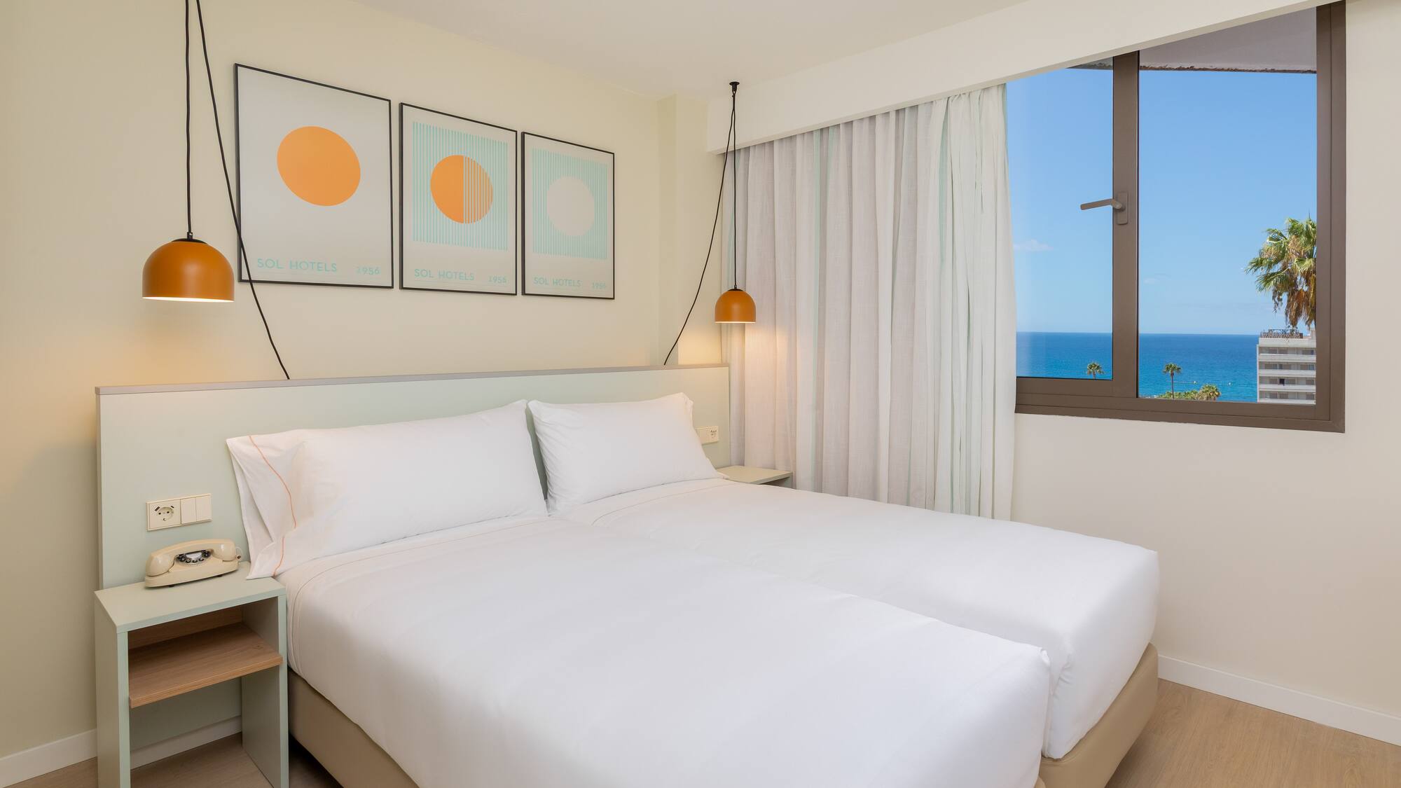 a bed with white sheets and pillows in a room with a window