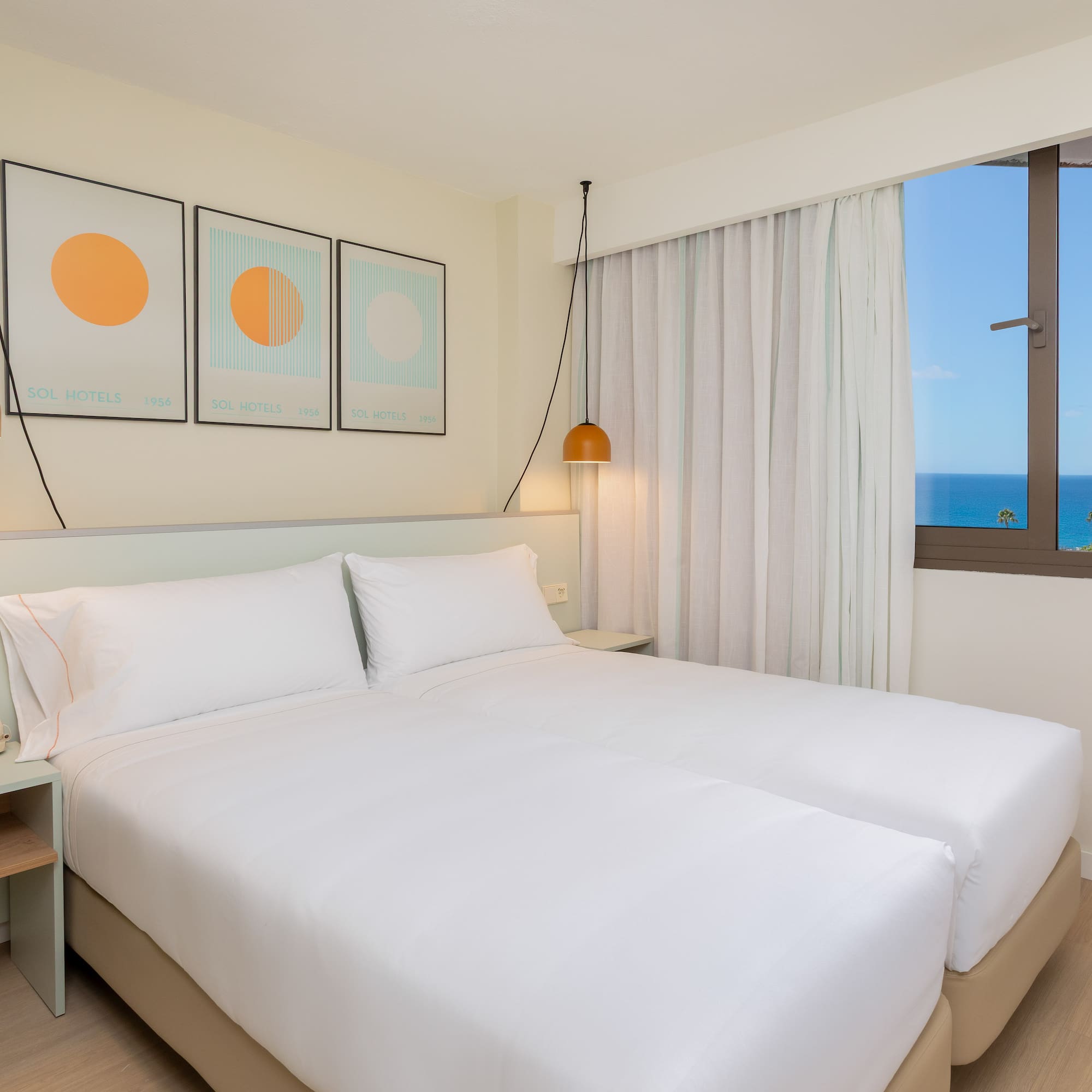 a bed with white sheets and pillows in a room with a window