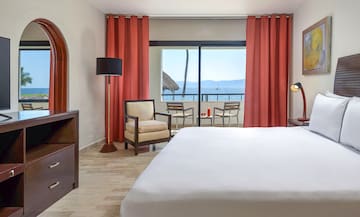 a room with a bed and chairs and a table and chairs