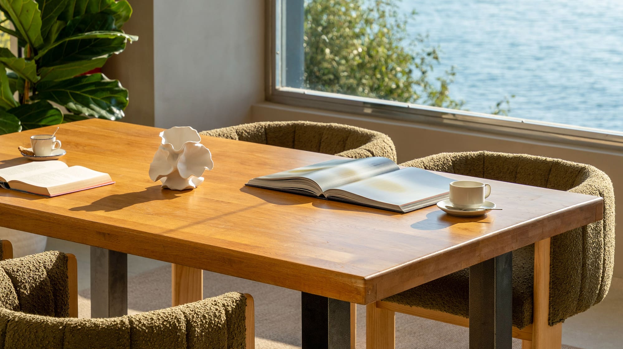 a table with a book and two chairs by a window