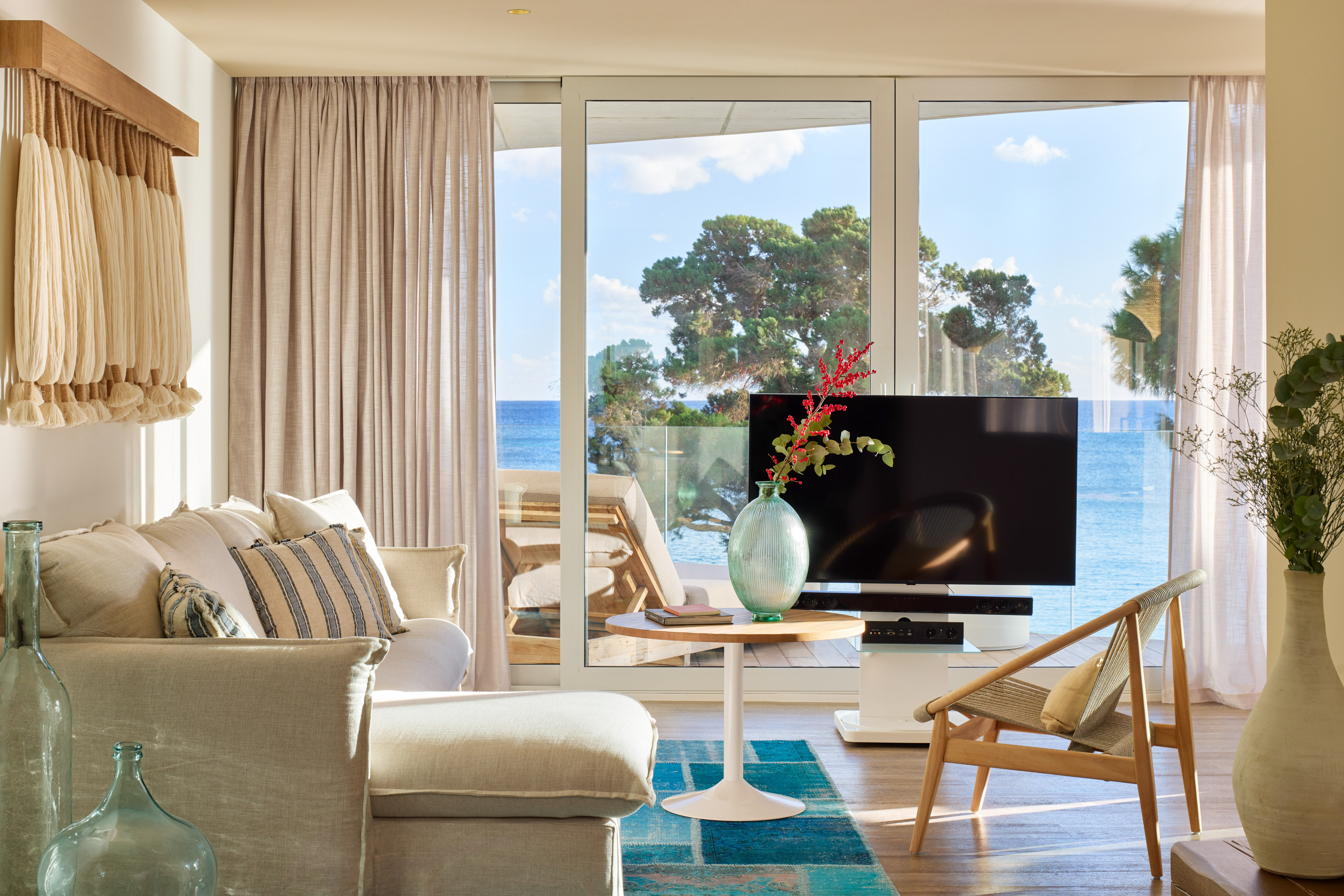 Bright living room with expansive ocean view, sofa, TV, and coastal decor.