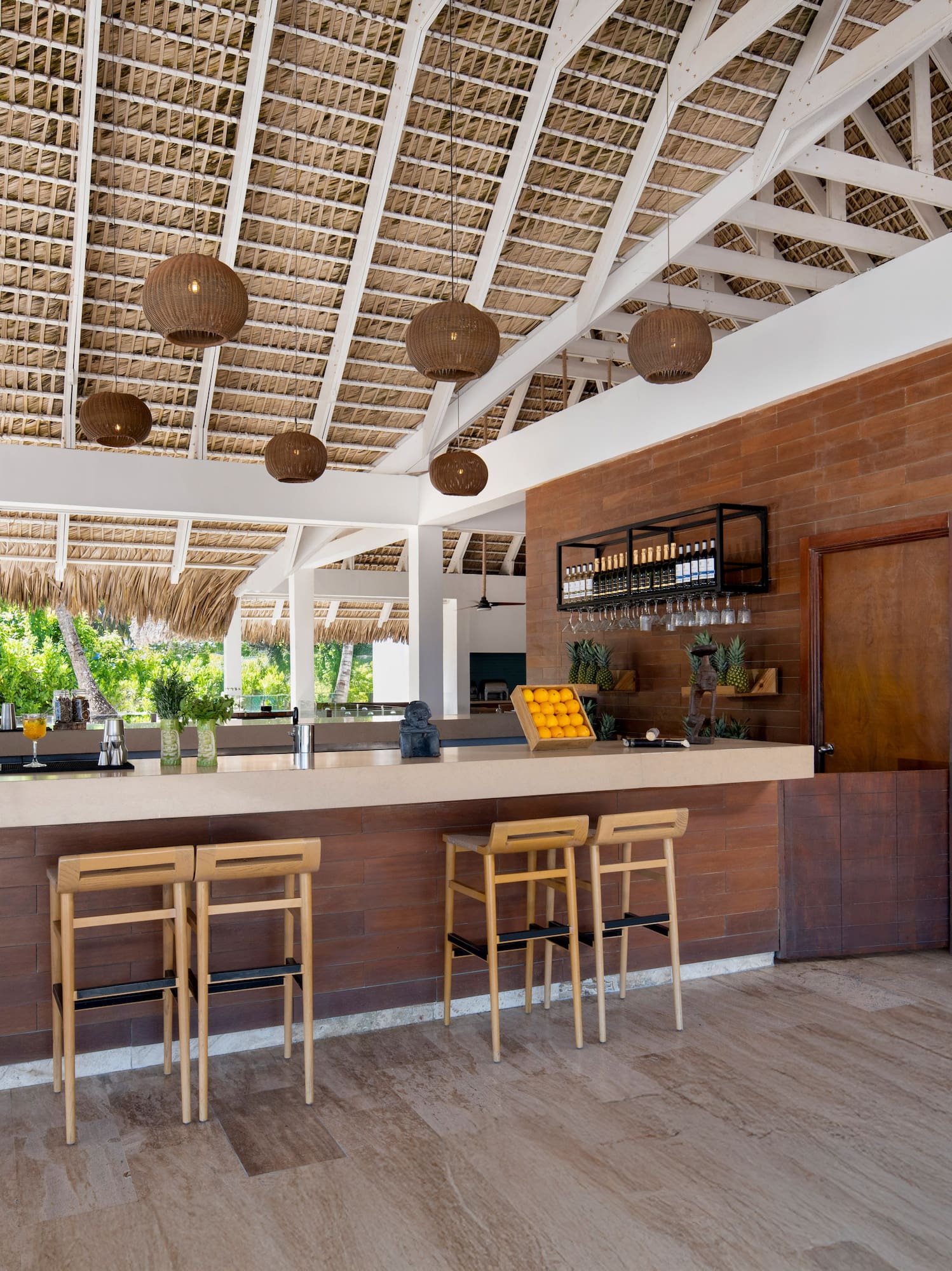 a bar with chairs and a straw roof