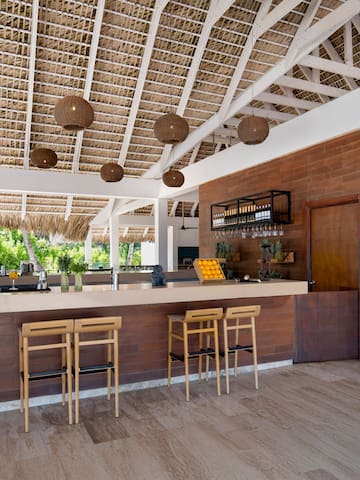 a bar with chairs and a straw roof