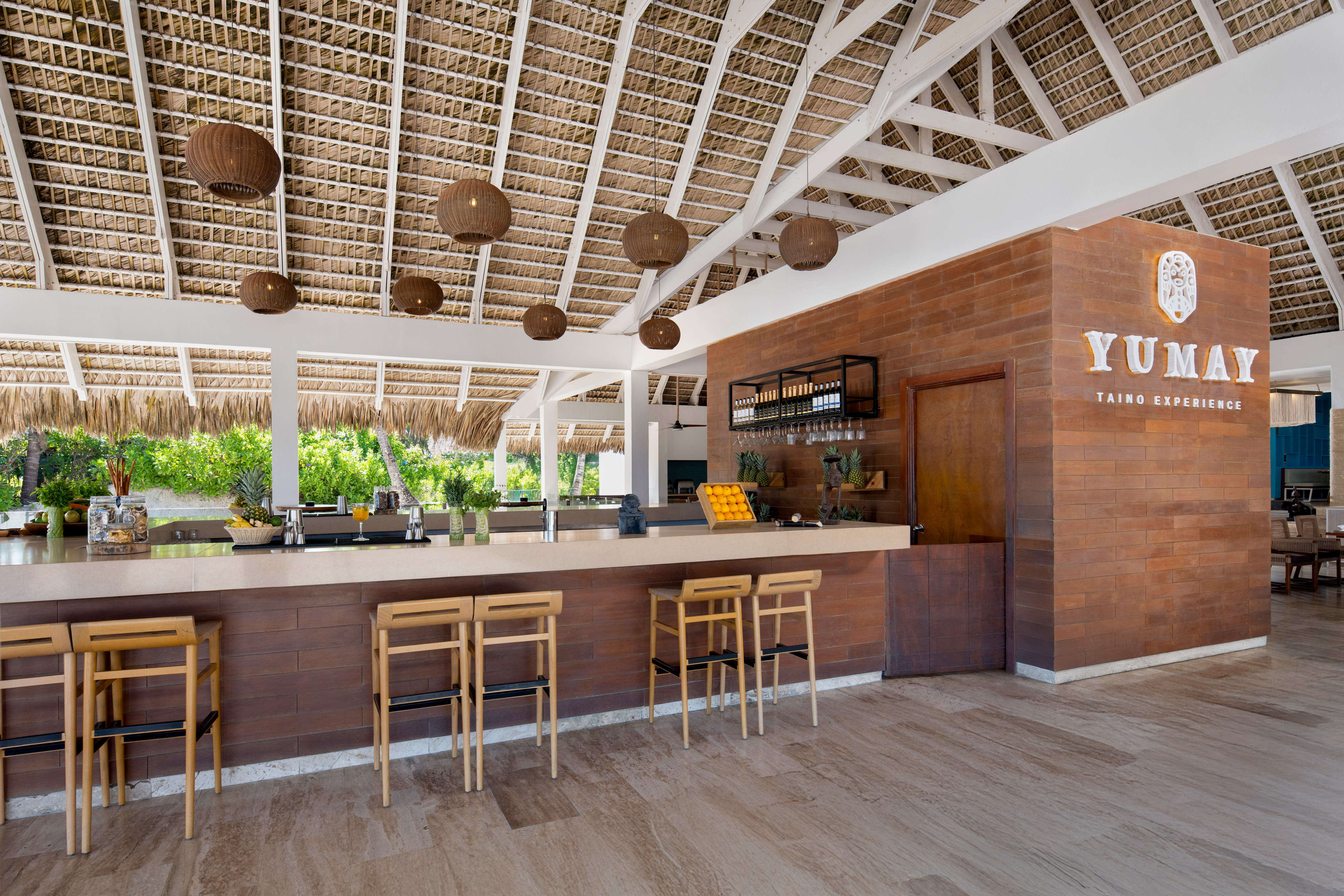 a bar with chairs and a straw roof