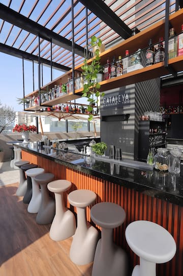 Cataleya Rooftop Bar with sleek counter, modern stools, and liquor display.