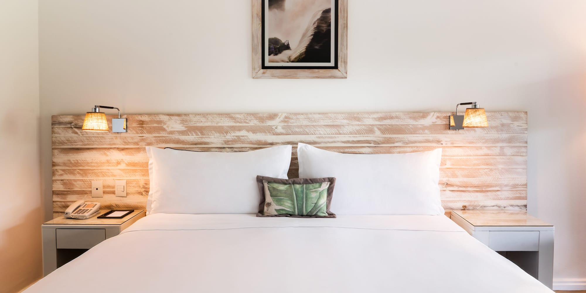 a bed with white sheets and pillows