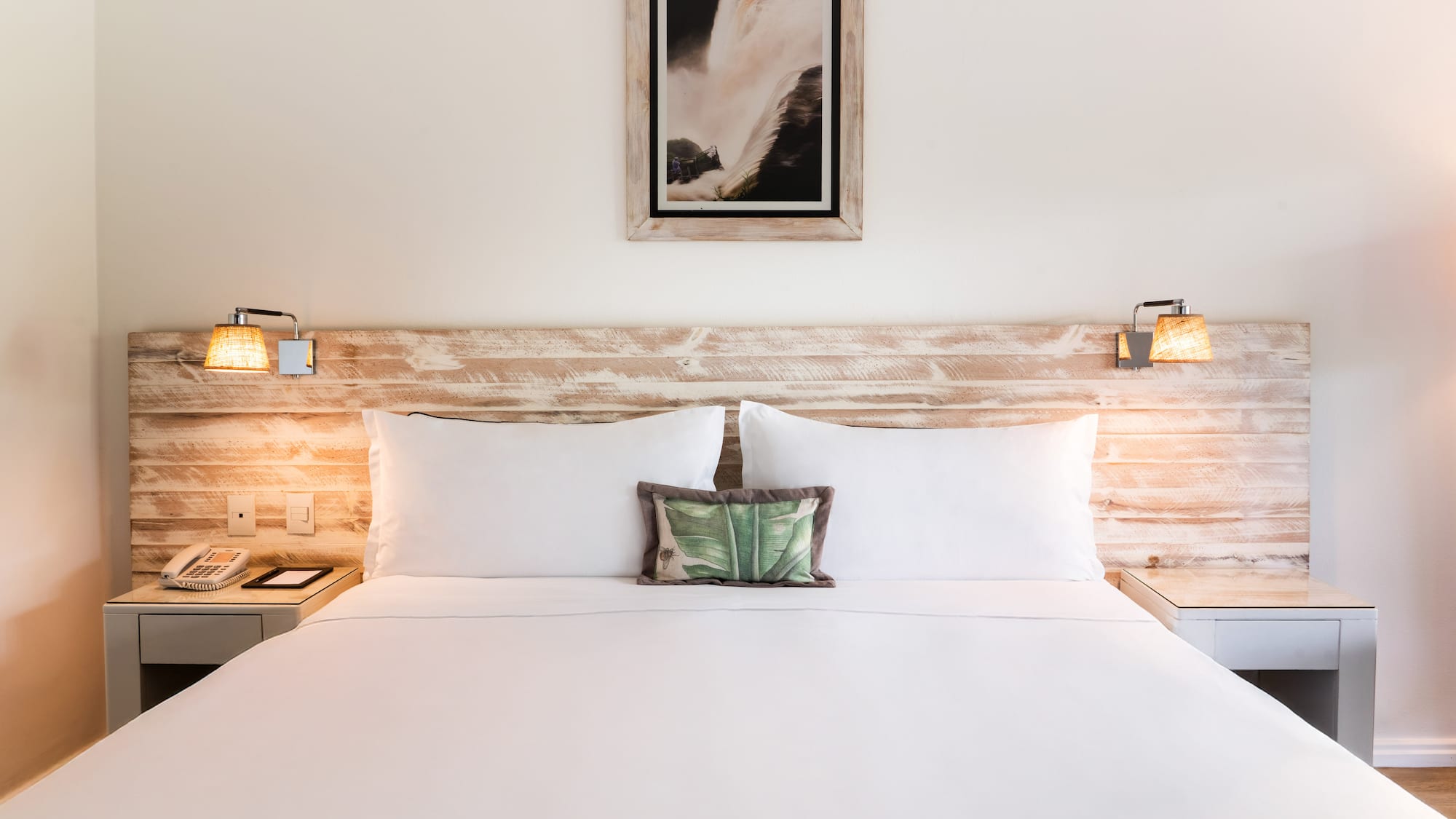 a bed with white sheets and pillows