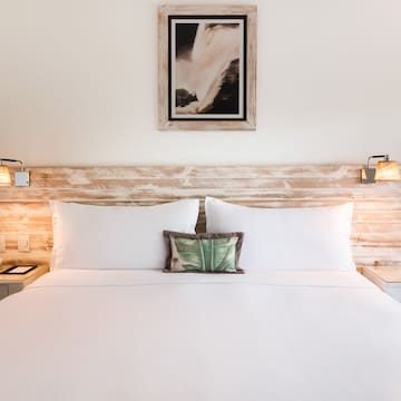 a bed with white sheets and pillows