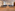Empty modern conference hall with rows of grey chairs on a hardwood floor.