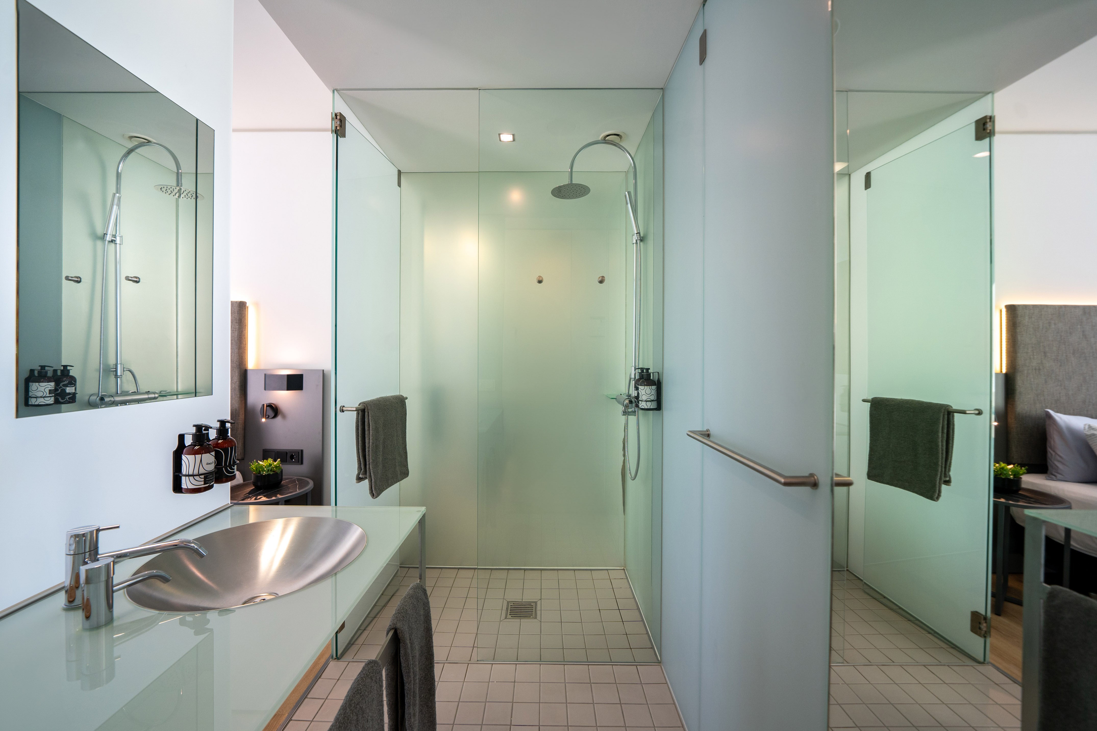 Sleek modern bathroom with frosted glass shower and metal basin.