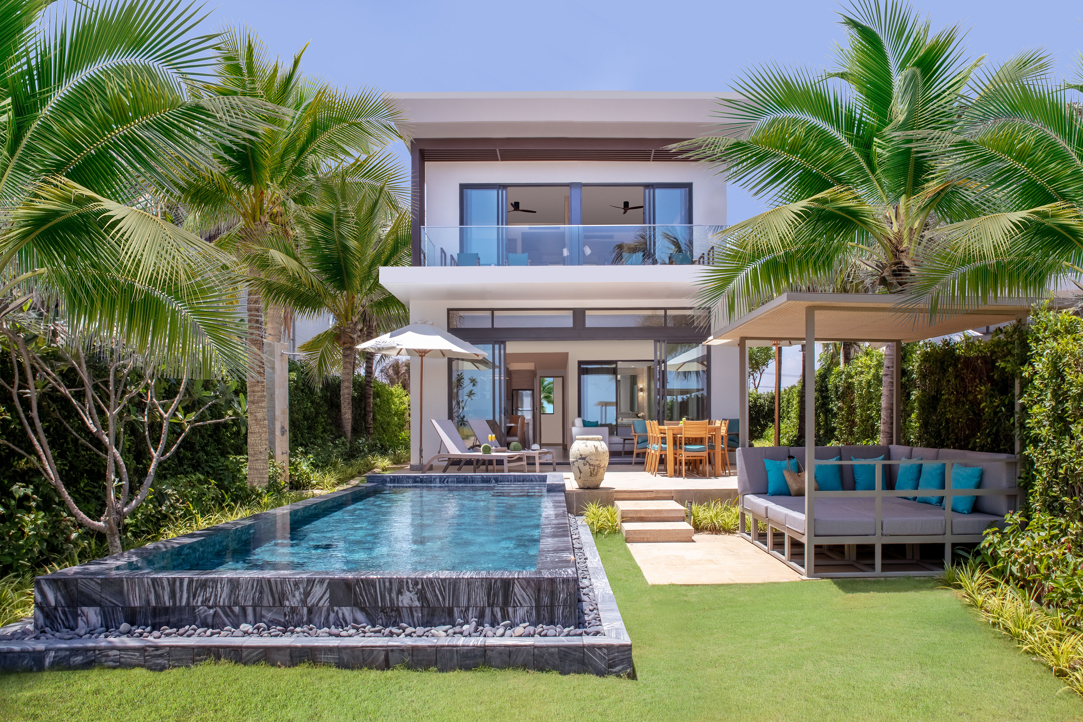 Modern tropical villa with private pool, outdoor lounge, and dining area.