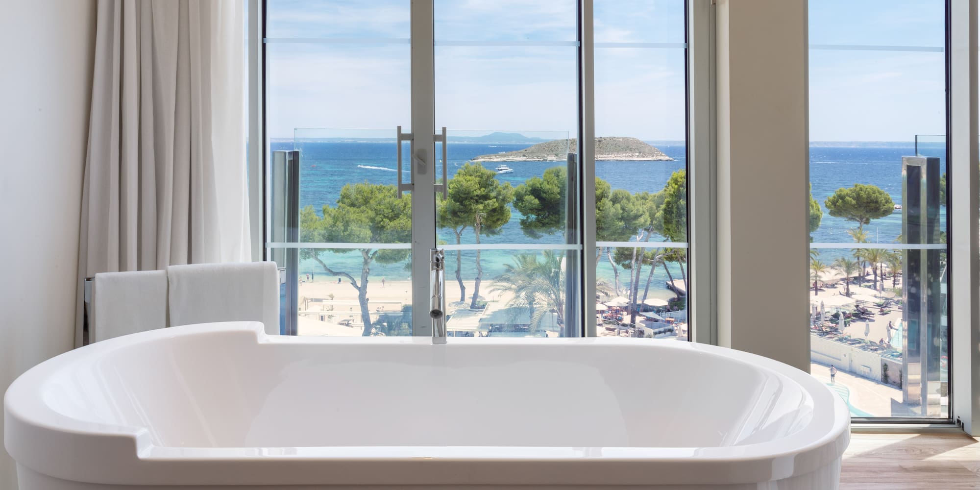 a bathtub with a view of the ocean and trees