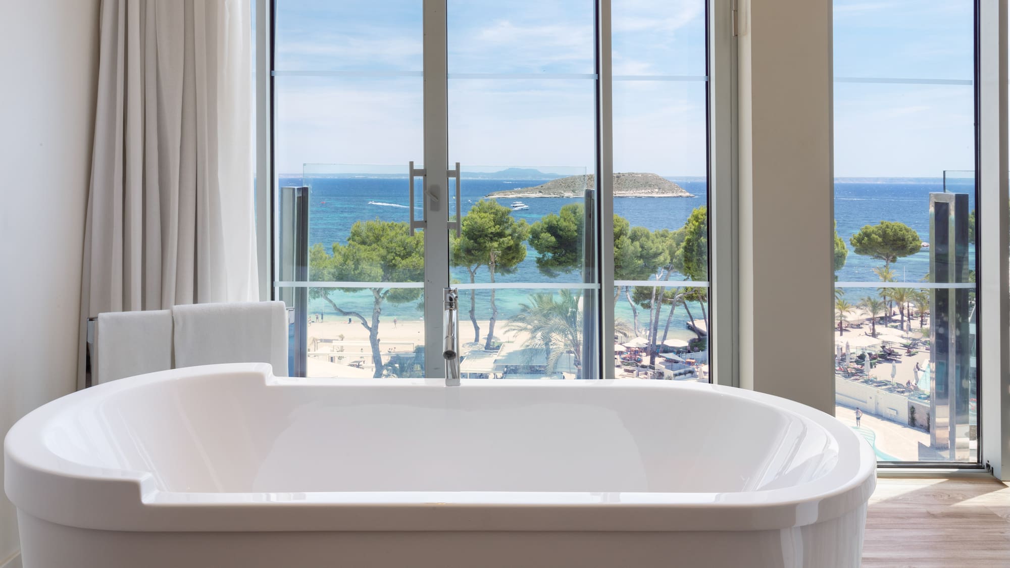 a bathtub with a view of the ocean and trees