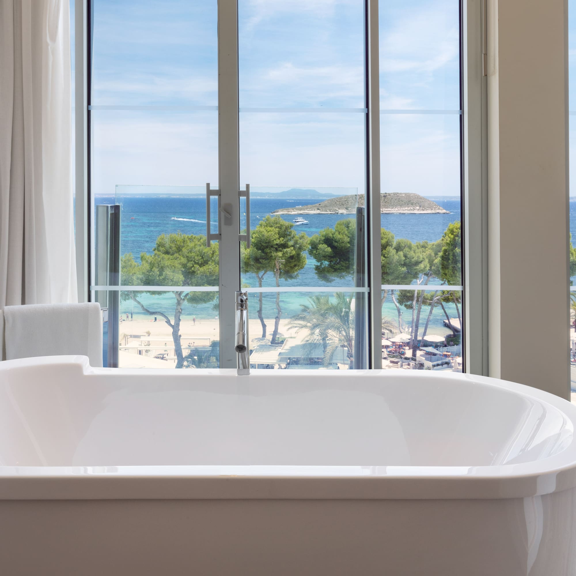 a bathtub with a view of the ocean and trees