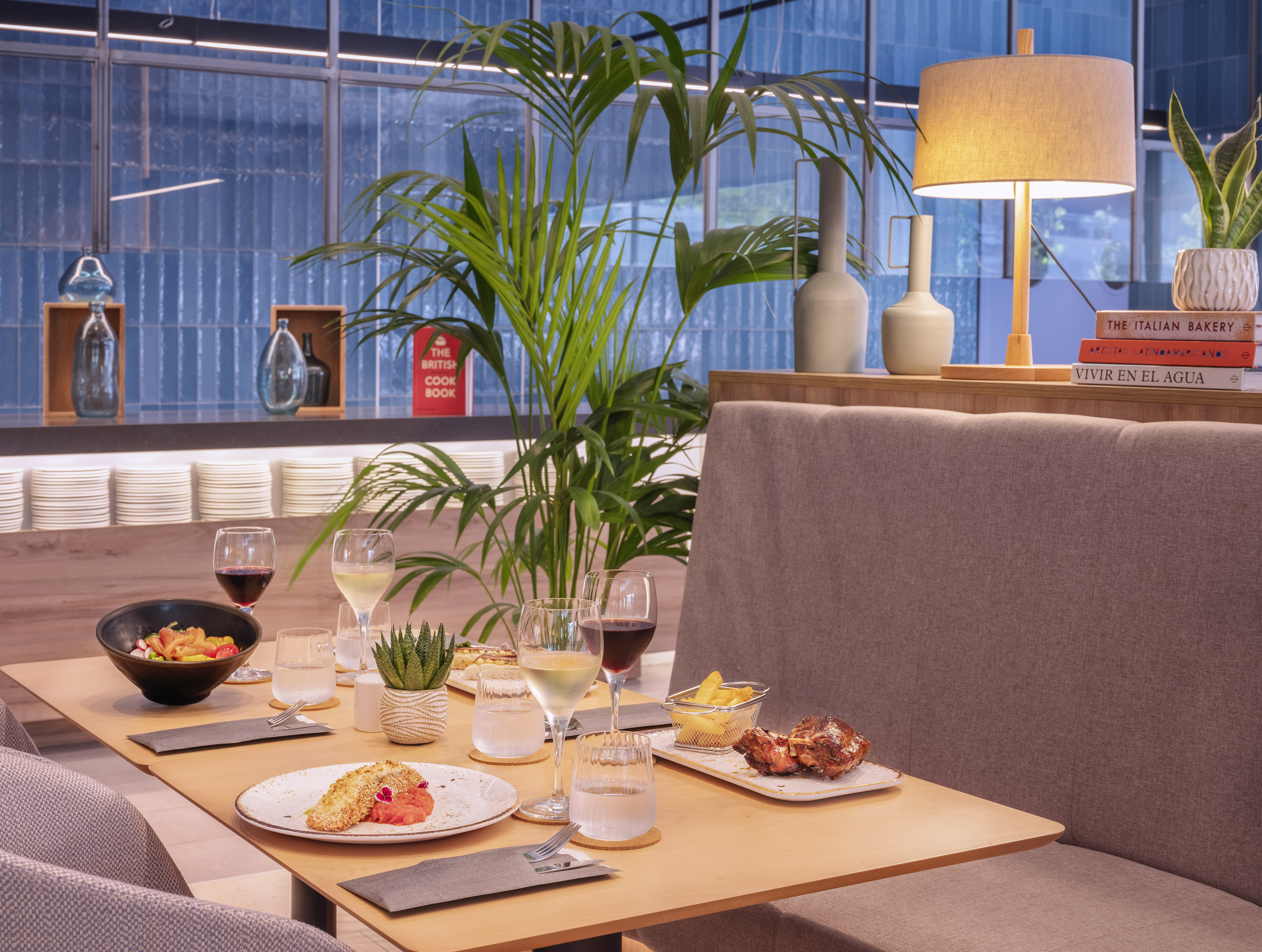 Modern restaurant dining table with plated meals, wine, and contemporary decor.