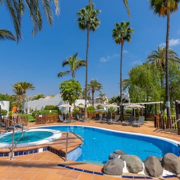 a pool with a hot tub and palm trees