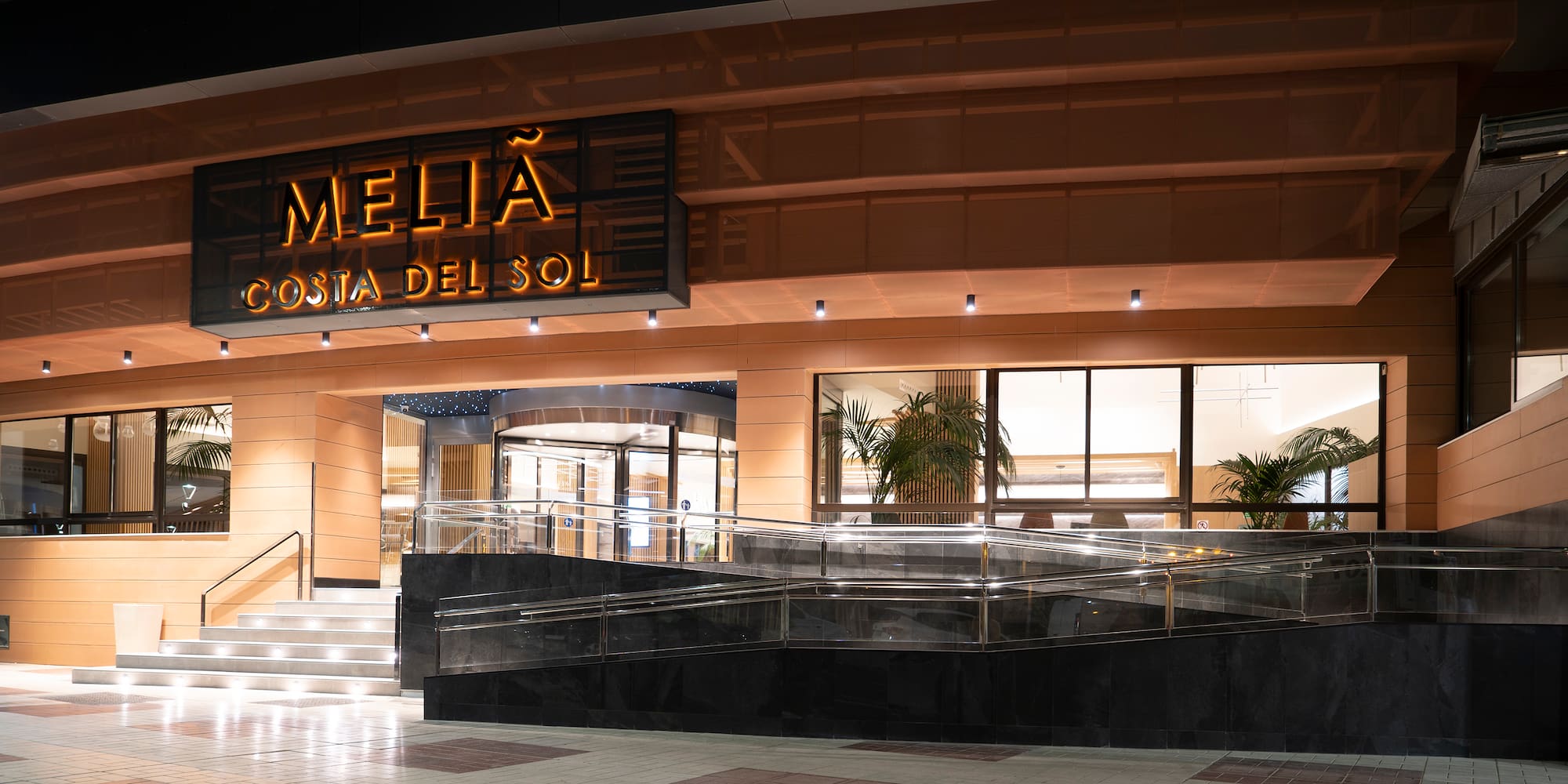 a building with a sign and a glass walkway