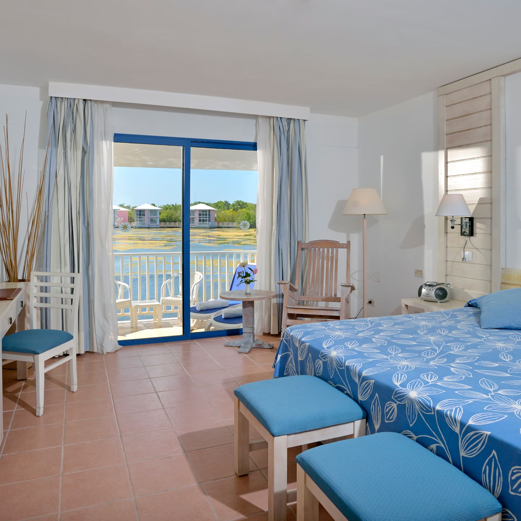 a room with a bed and chairs and a table