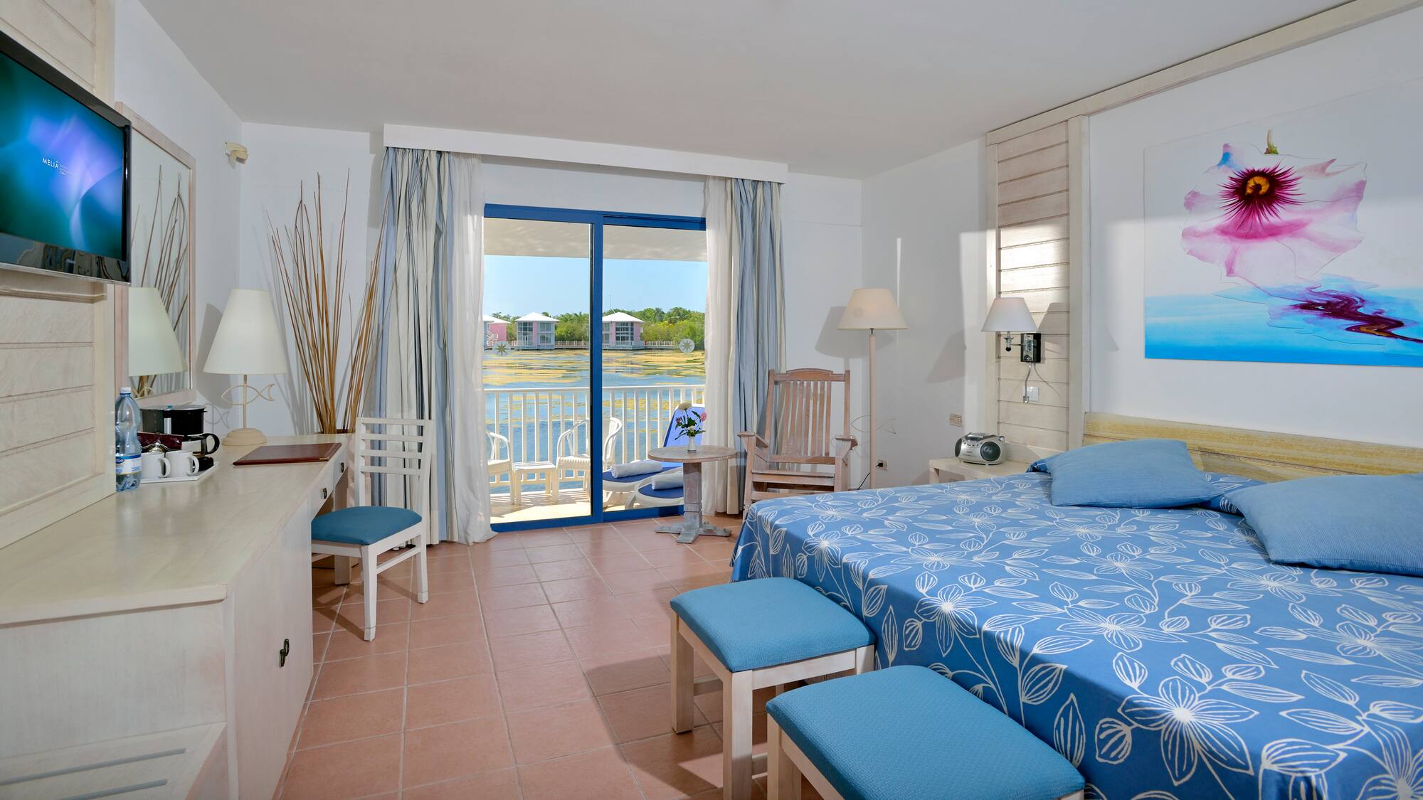 a room with a bed and chairs and a table