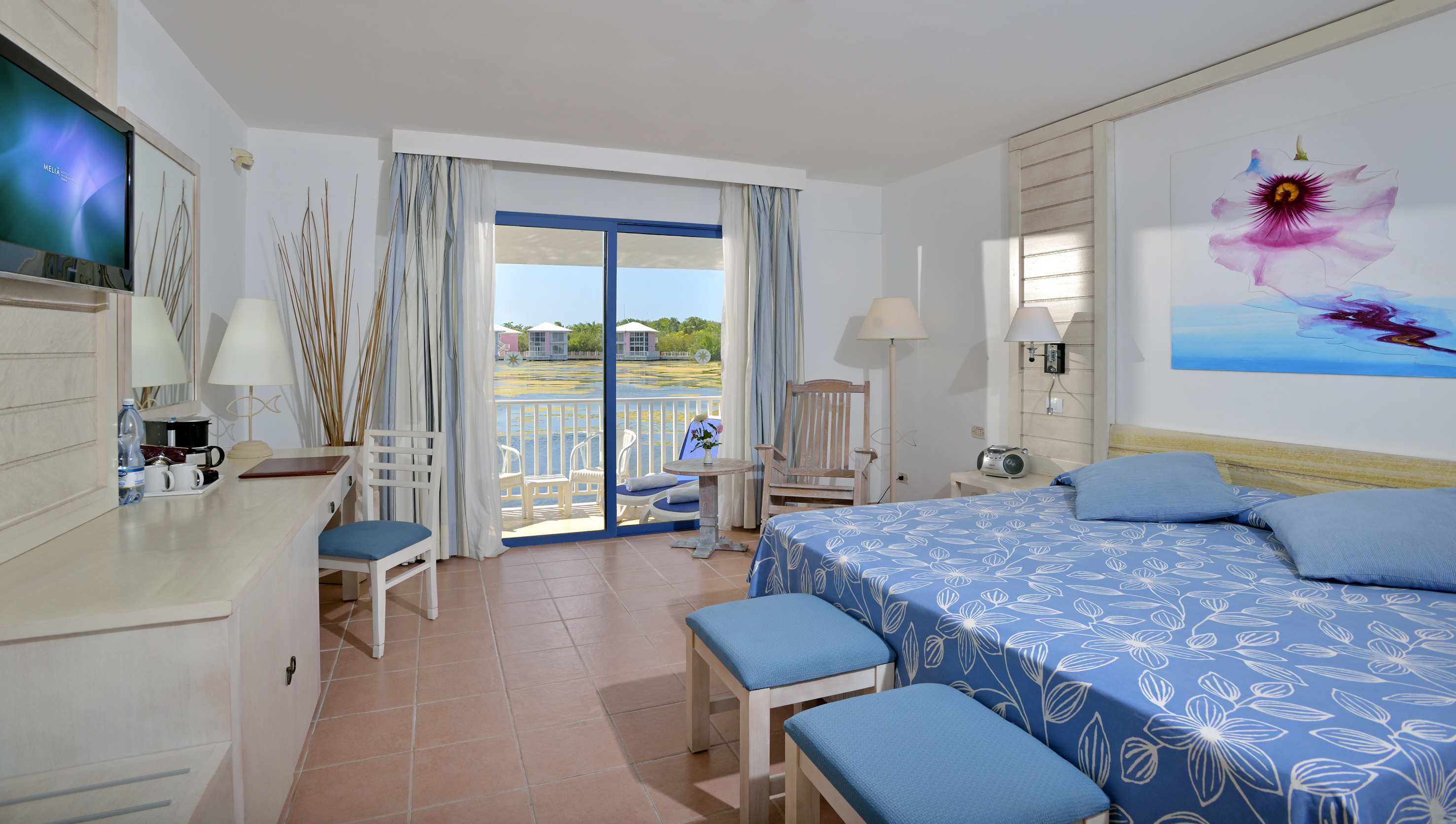 a room with a bed and chairs and a table