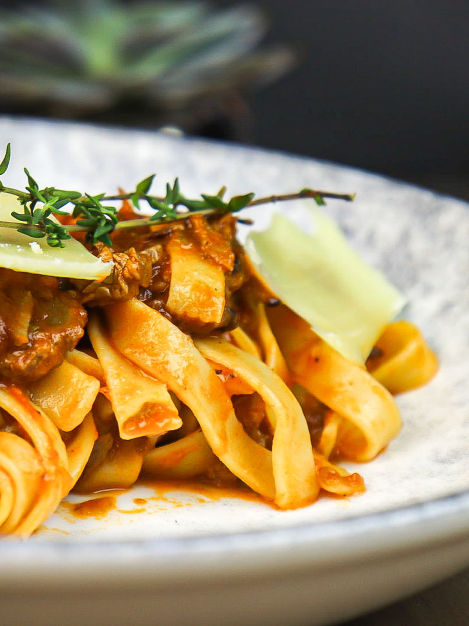 a plate of pasta with sauce and herbs