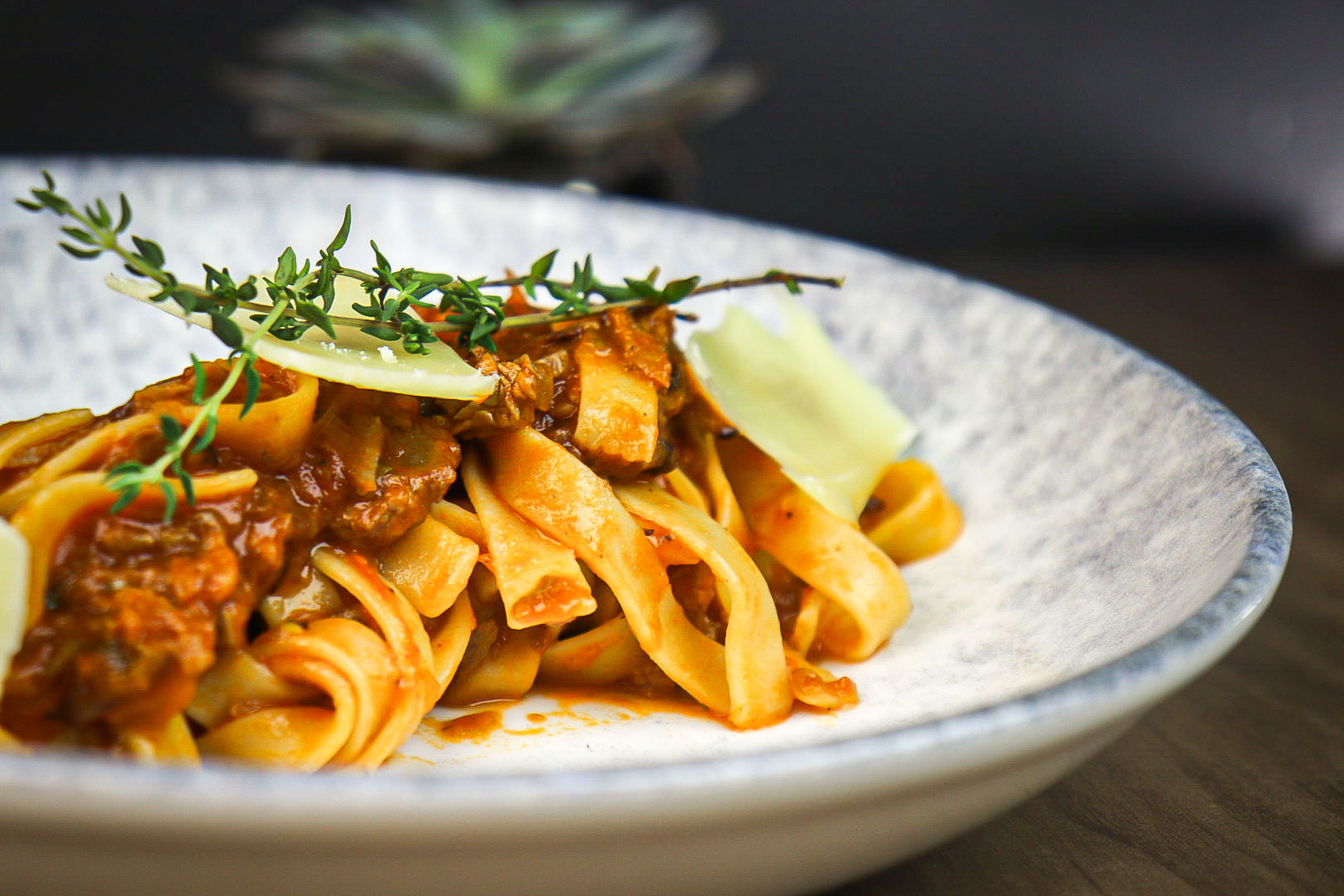 a plate of pasta with sauce and herbs