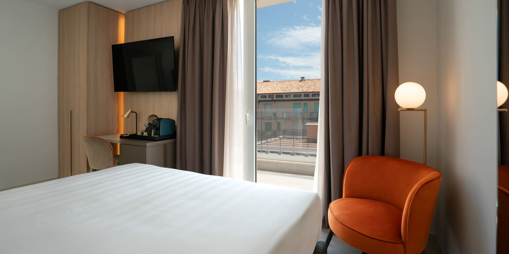 a room with a bed and a chair and a television